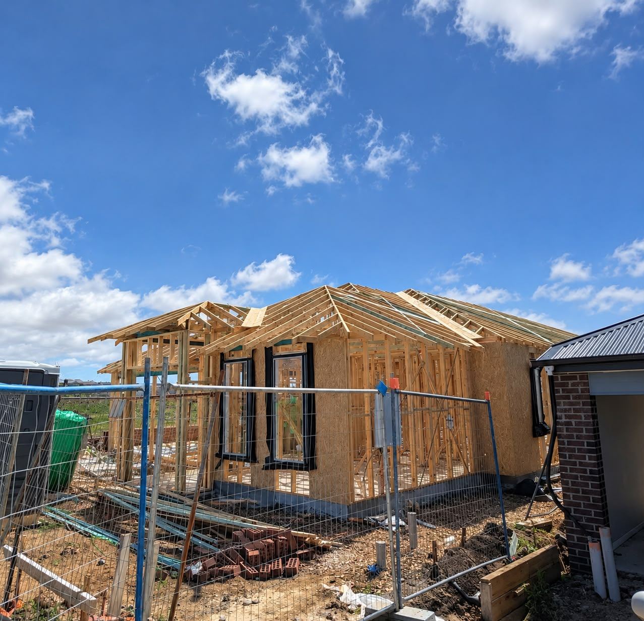 Single-storey timber wall frame and pitched roof trusses on a new home site in Western Sydney